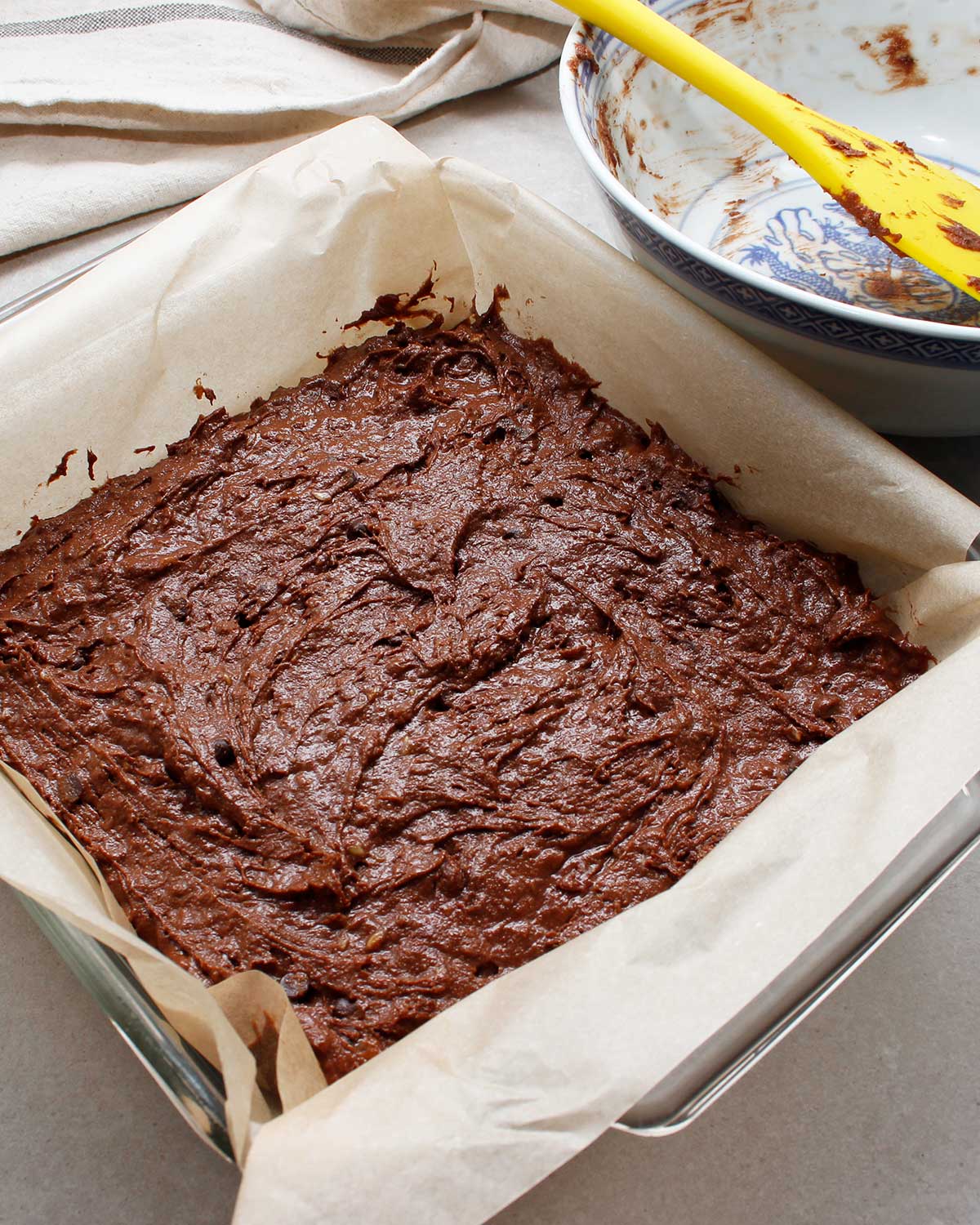 Gluten-free vegan brownie batter in square baking pan.