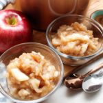 Two small glass bowls of homemade chunky style applesauce.