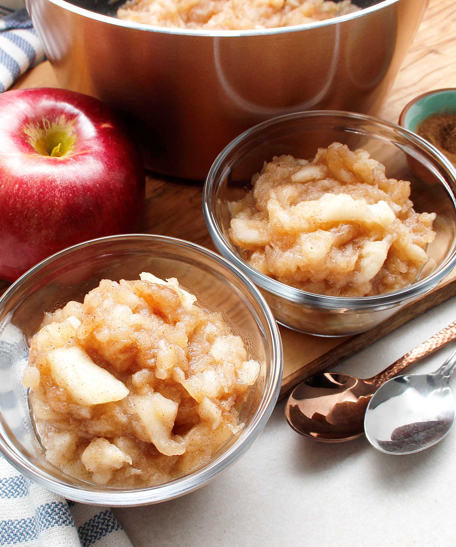 Two small glass bowls of homemade chunky style applesauce.