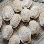 Lemon Madeleines cooling on wire rack with a perfect dusting of organic powdered sugar.