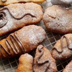 Cooled and decorated GF vegan Canadian Sourdough Beavertails donuts on a wire rack.