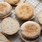 Soft gluten-free vegan sourdough buns cooling on a wire rack.